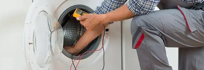 Dryer repair technician inspecting and repairing a clothes dryer in Tempe, AZ