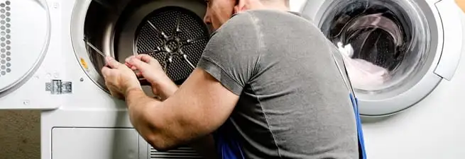 Dryer repair technician fixing a clothes dryer drum in Tempe, AZ