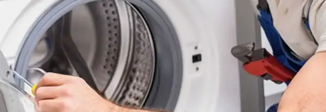 Appliance technician repairing a clothes dryer drum and internal parts in Tempe, AZ