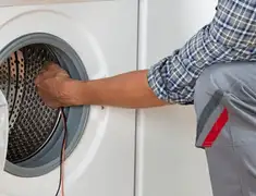 Dryer repair technician diagnosing and servicing a clothes dryer in Tempe, AZ