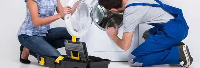 Washer repair technician inspecting a front-load washing machine with tools in Tempe, AZ