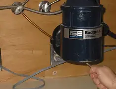 Garbage disposal repair technician tightening the mounting ring under a sink in Tempe, AZ
