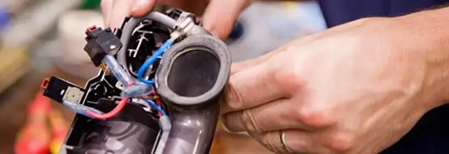 Vacuum repair technician reconnecting wiring and components in Tempe, AZ