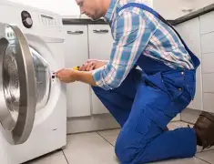 Washing machine repair technician servicing a front-load washer in Tempe, AZ