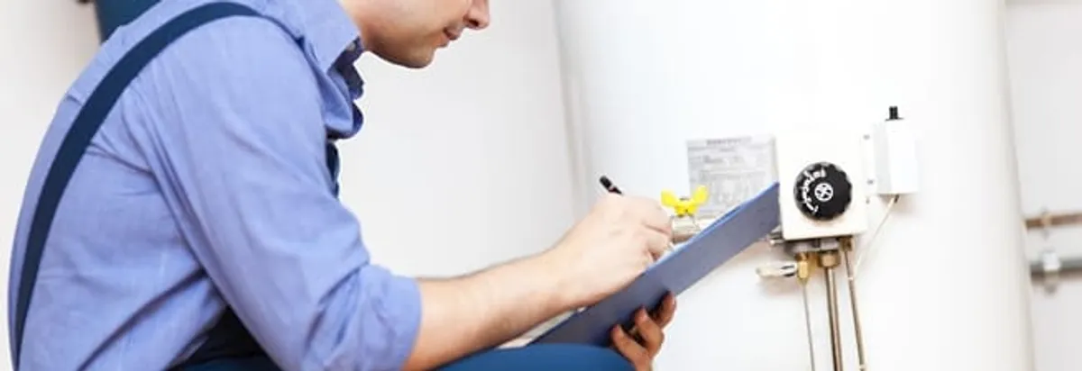 Water heater repair technician inspecting the unit and recording service notes in Tempe, AZ