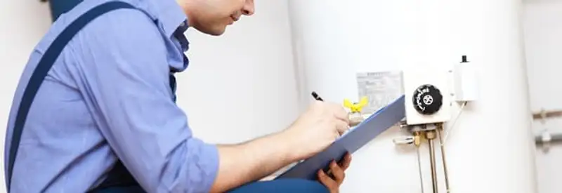 Water heater repair technician inspecting the unit and recording service notes in Tempe, AZ